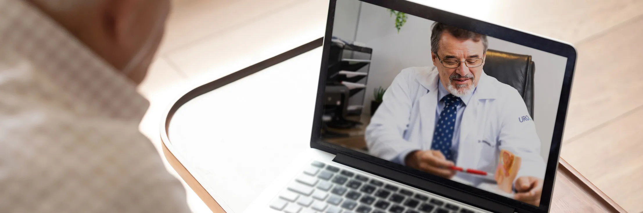 Paciente sentado em frente ao computador em consulta virtual com seu médico